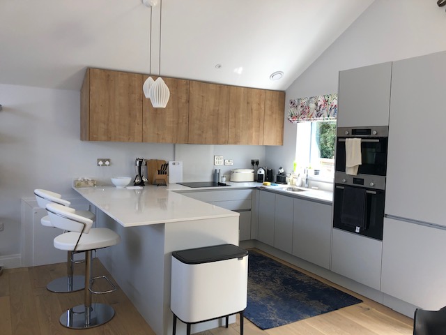 Breakfast bar with oak wall cabinets and built-in ovens