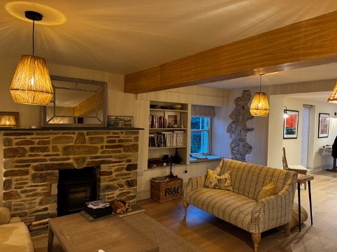 Snug at Mays Cottage with a stone fireplace, oak beam and wood burner