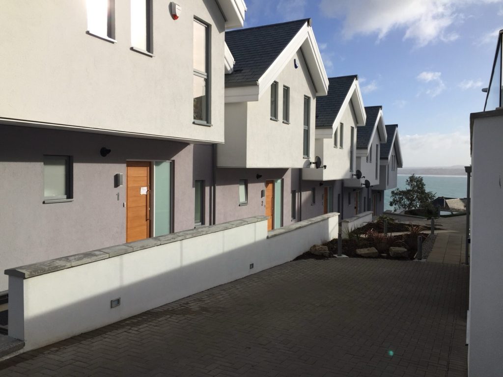 A row of homes at Constantine Bay, with the sea at the end of the path