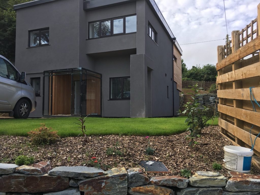 Garden elevation of Tre’n Vownder, Truro, with a glazed porch and timber cladding